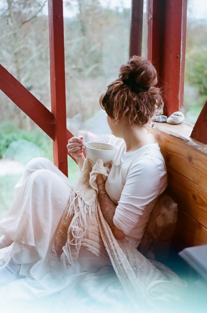 woman in white dress holding white ceramic mug